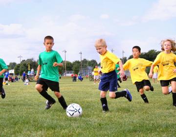 des enfants jouent au foot lors d'une activité scolaire