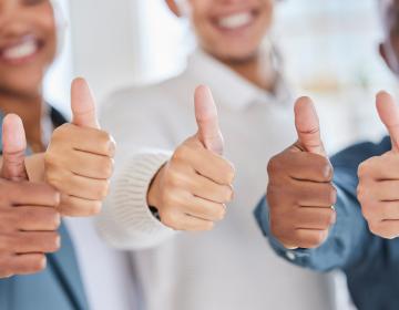 trois personnes qui lèvent le pouce pour montrer leurs satisfaction client