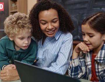 Une femme et des enfants devant un ordinateur